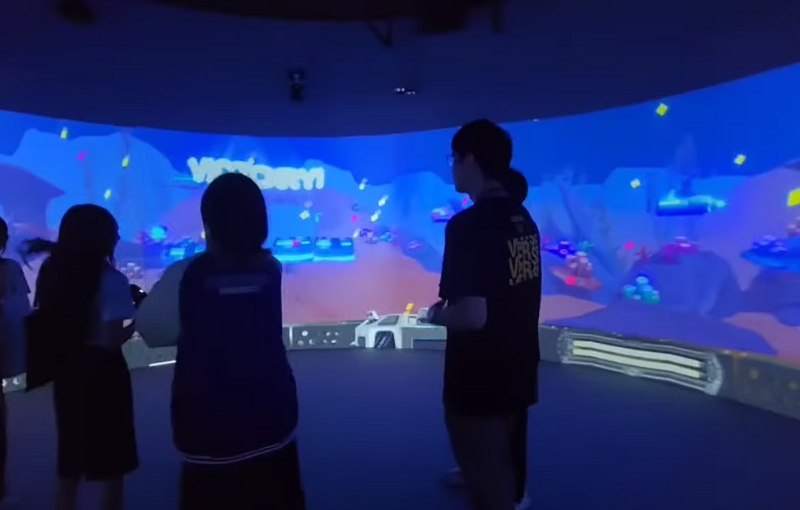 Visitors interacting with blue panoramic projections inside the SPU Immersive Room.